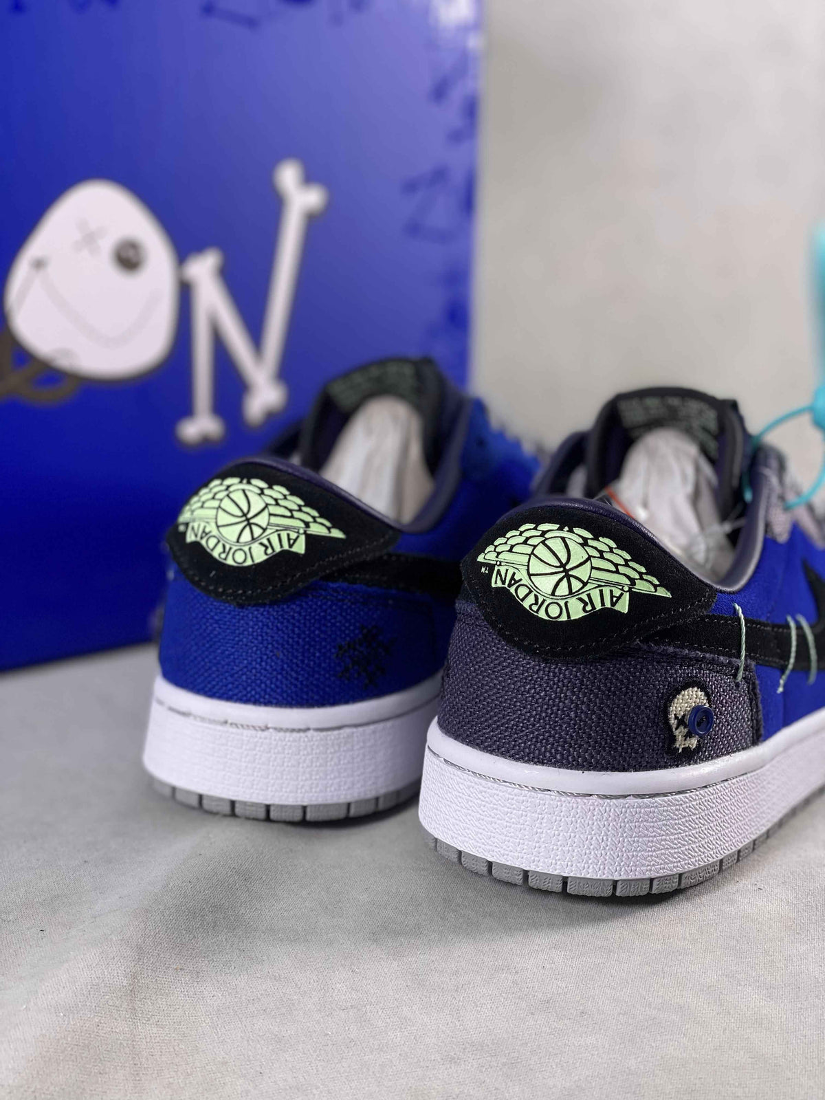 Designer Air Jordan sneakers in blue and black canvas with unique stitched skull logo, luxury urban wear style